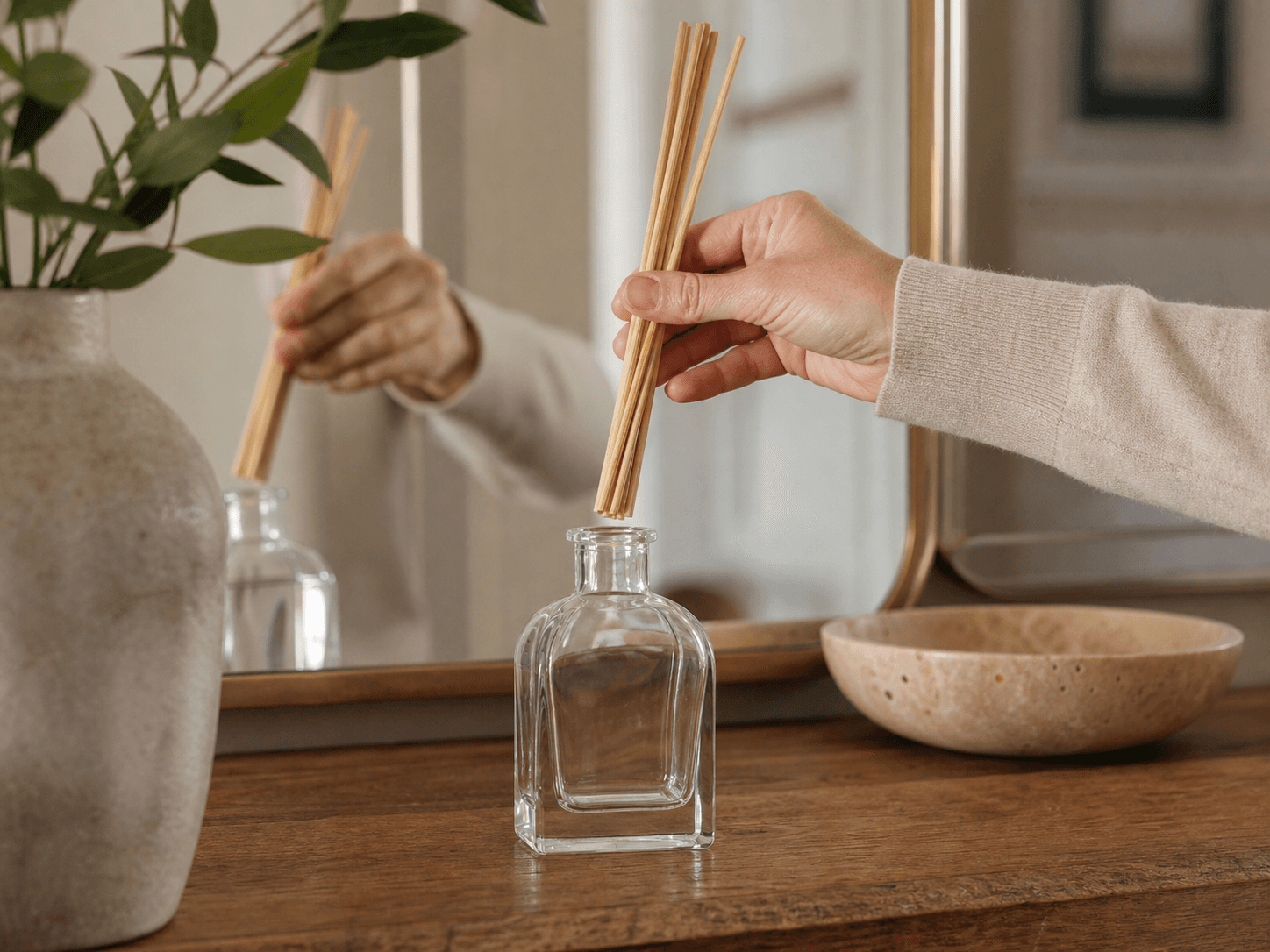 Rattan Reed Diffuser Bottle used for reeds turned over a wooden surface in a hallway consoles setting